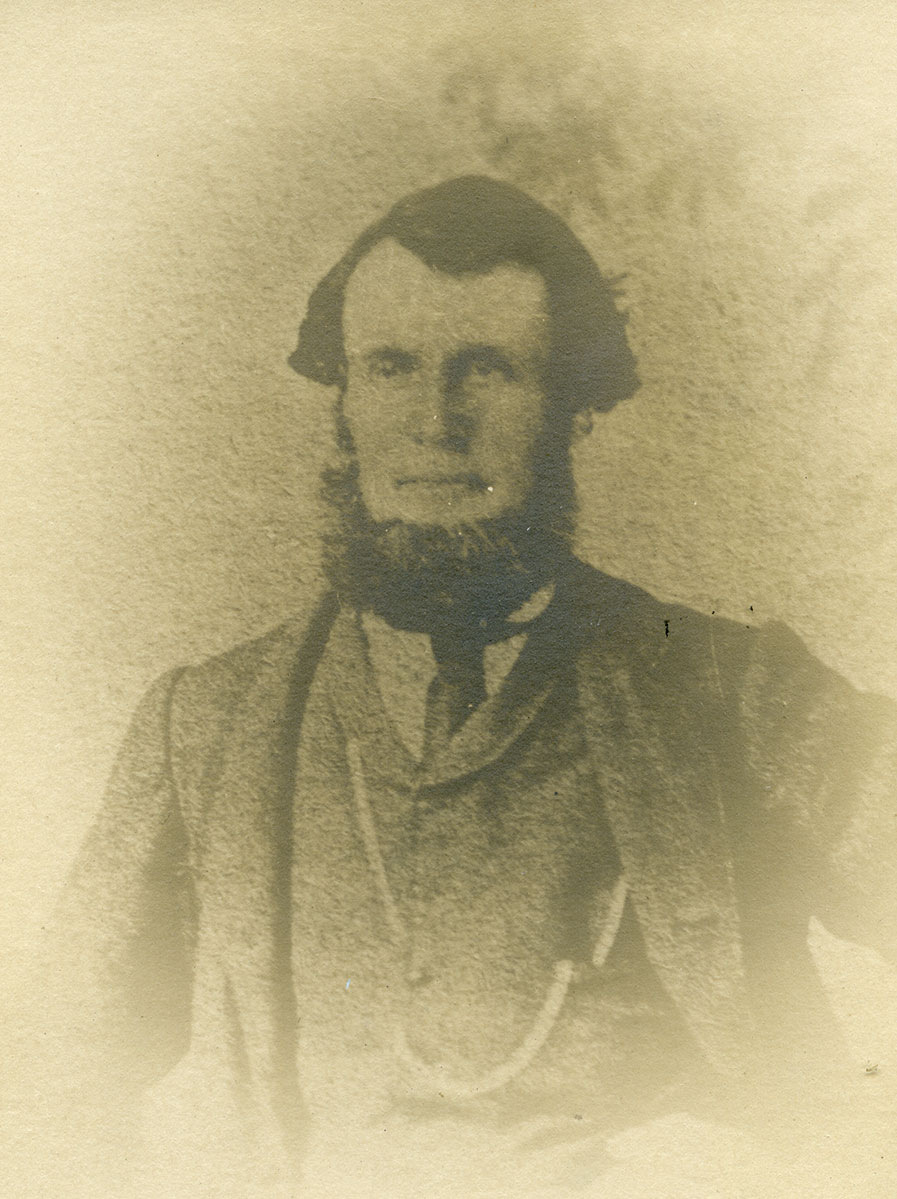 Historic image of an adult white male from the 1800s wearing a formal jacket and shirt.