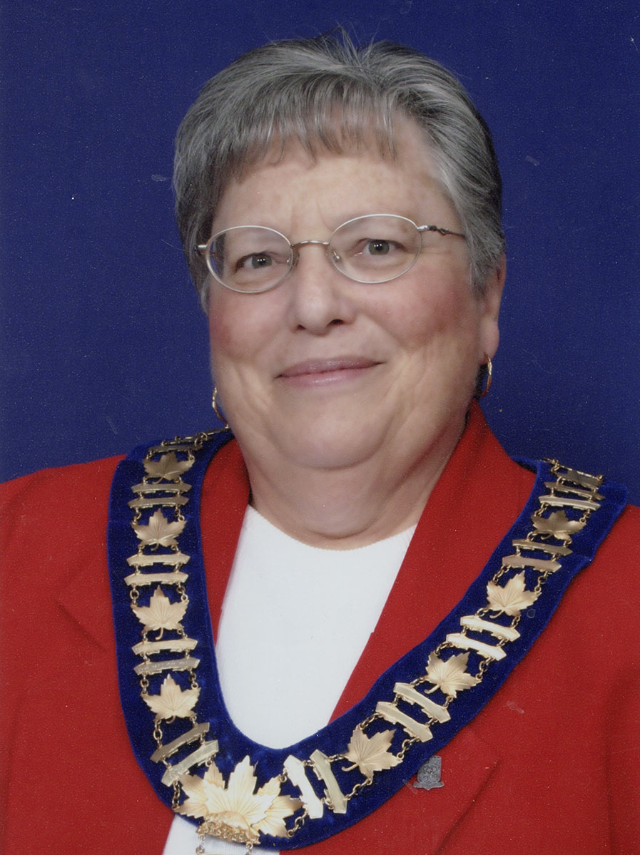 Photo of a woman in a suit and warden medal.