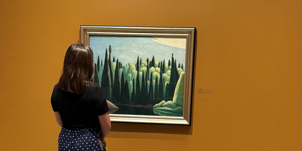 A visitor looks at Spring on the Oxtongue River by Group of Seven artist Lawren Harris, currently on display at JNAAG