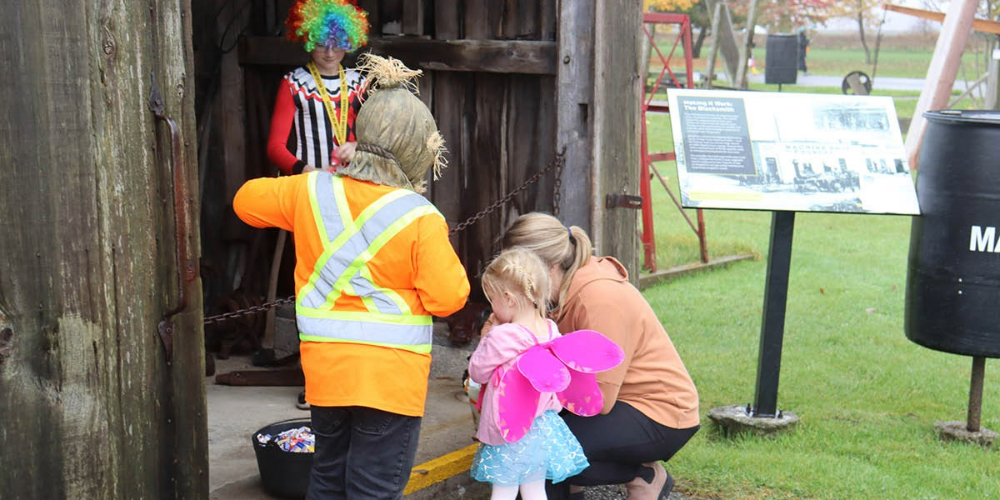 Costumed children trick-or-treat in historic buildings at Oil Museum in 2023