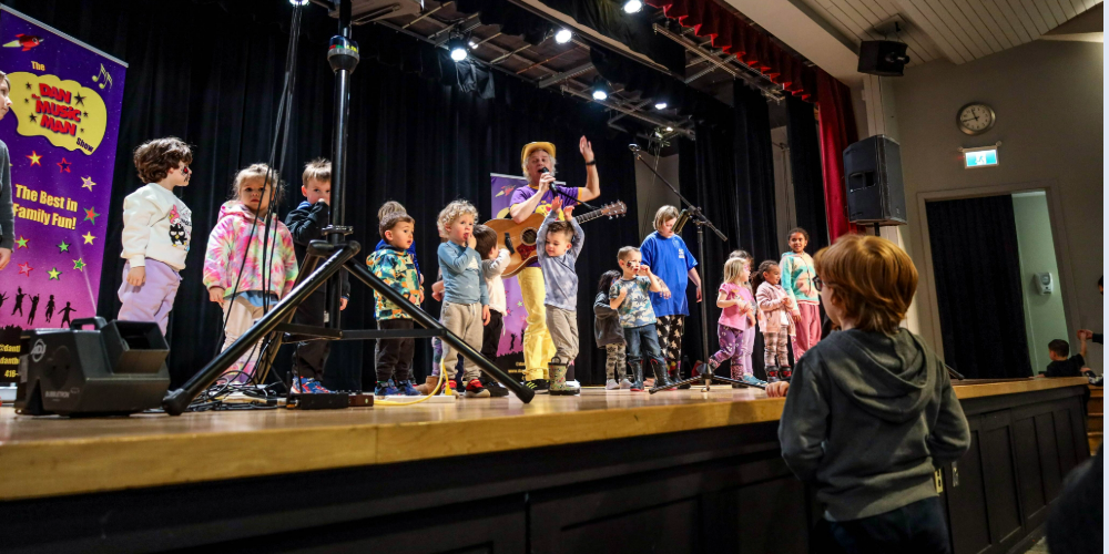 Children's entertainer, Dan the Music Man, performs on-stage at Sarnia Library Theatre during the 2024 Family Literacy Day Festival