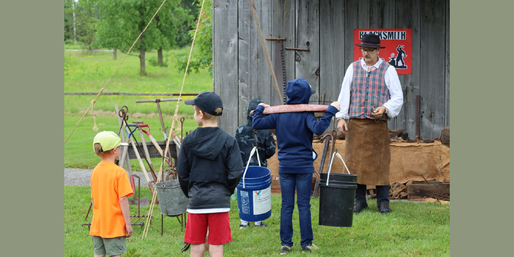 Visitors participate in a historical blacksmithing demonstration at Black Gold Fest in 2023